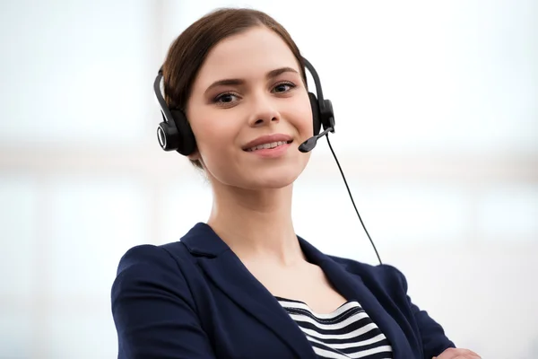 Smiling call center female operator with headphones