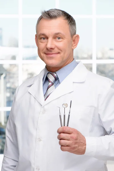 Dentist holding stomatologist tools
