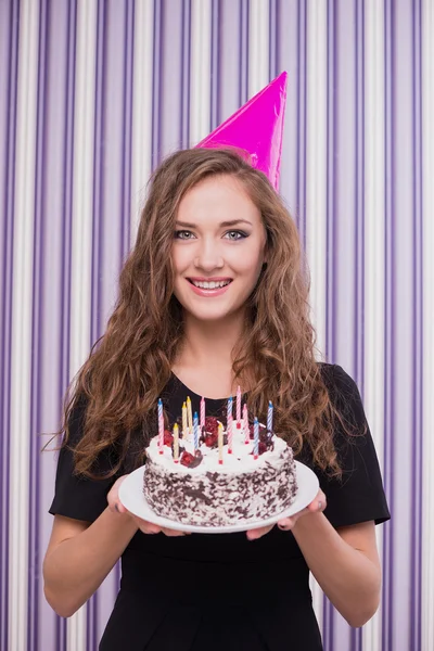 Happy woman with birthday hat and cake