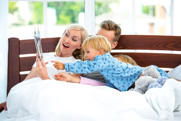 Young family on white bed
