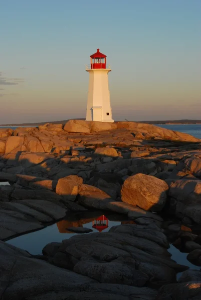 Historic Peggy\'s Cove lighthouse reflected in a still pool