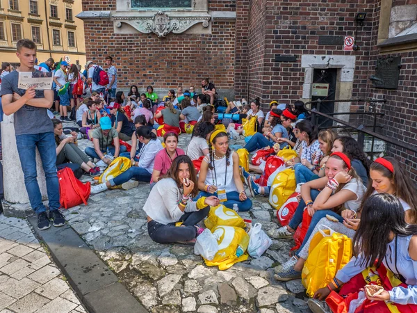 World Youth Day 2016. Toung pilgrims resting in the shadow of the church