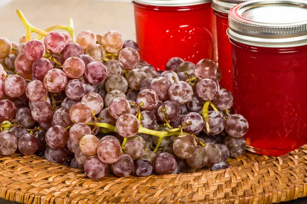 Jars of pink grape jelly with grapes