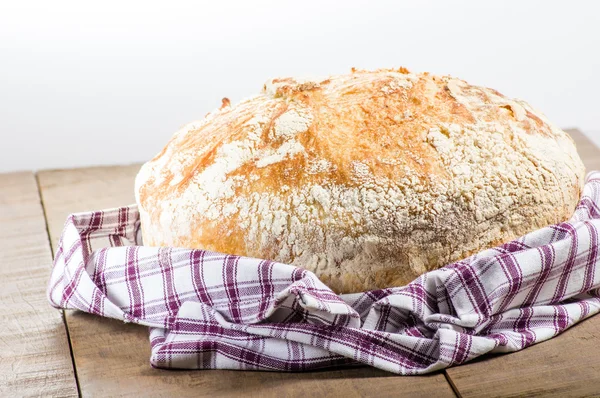 Fresh baked loaf of bread in cloth