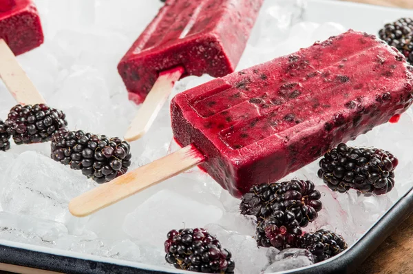 Frozen berry pops on tray of ice