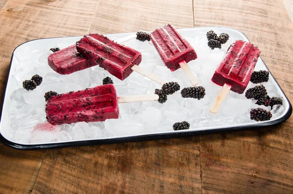 Frozen berry pops on tray of ice