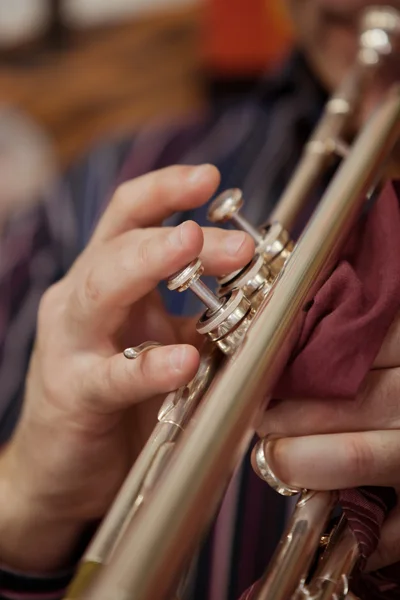 The hand of a man playing the trumpet