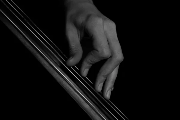 The fingers on the strings of the cello