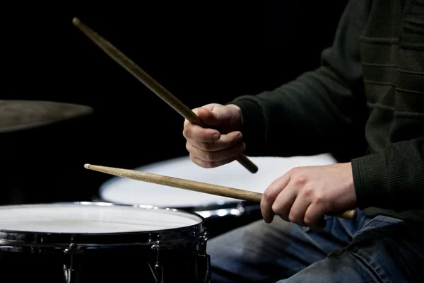 Hands of a man playing a drum set