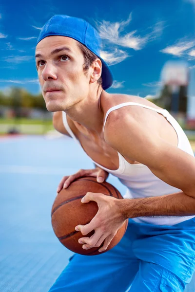 Young guy playing basketball. He is preparing to throw the ball