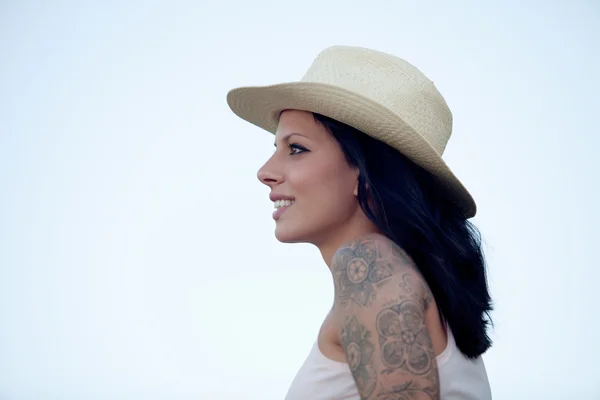 Brunette woman with tattoo on the arm looking forward