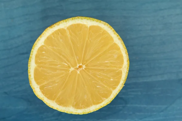 Half lemon on a blue wood