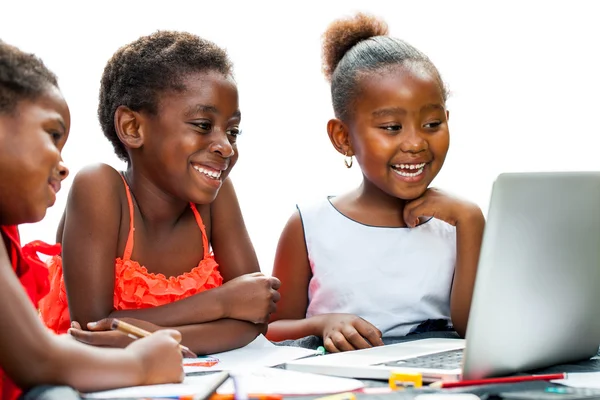 Three African kids laughing at scene on laptop.