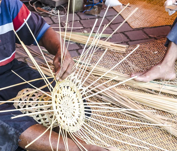 Old hands manually weaving