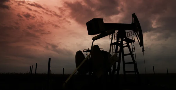 Oil and gas well profiled on dramatic sky