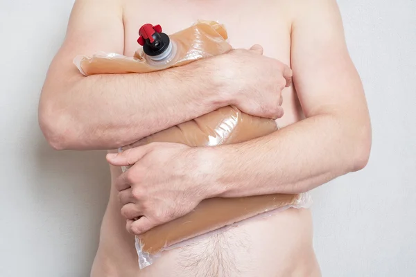 Man holding plastic bag with tap full of apple juice