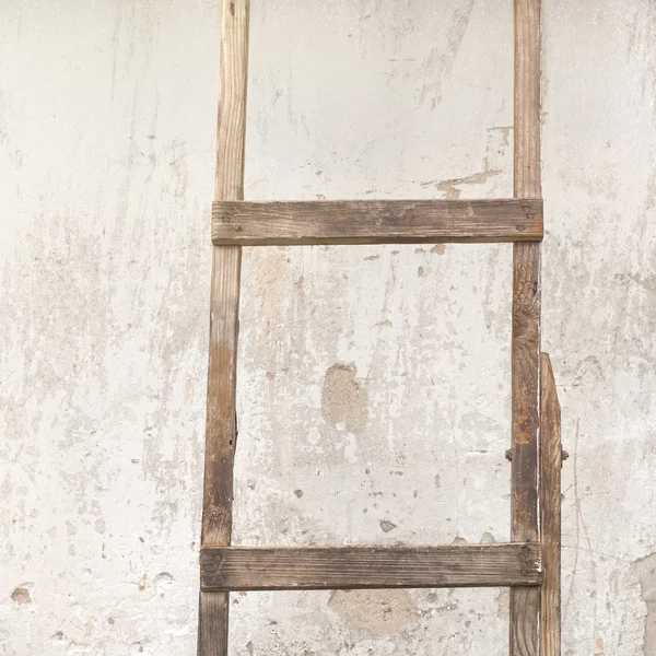 Weathered stucco wall with wooden ladder