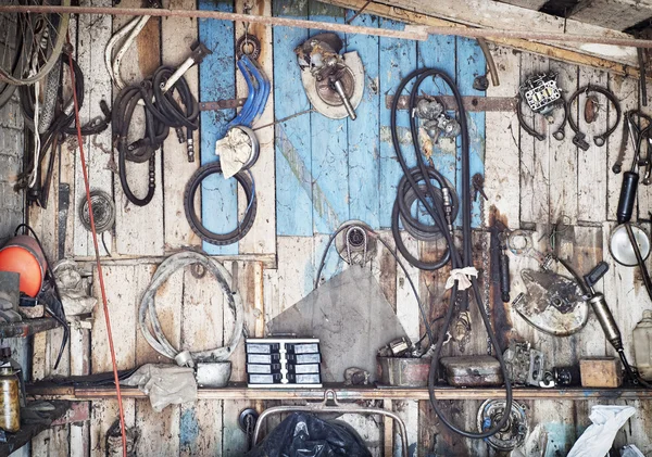 Old tools hanging on wooden wall