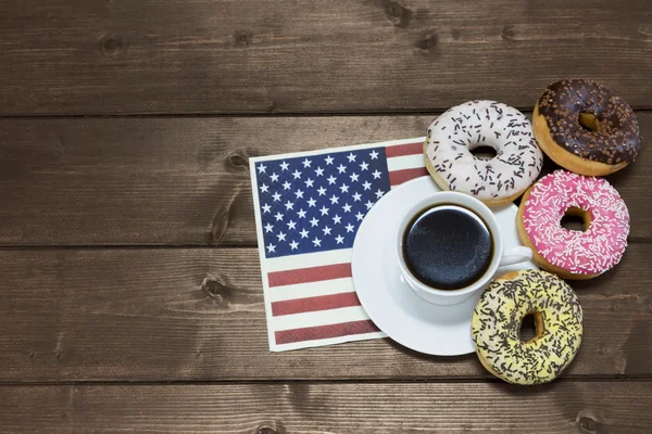 American donuts around the cup of coffee