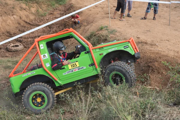 Side view of a green small off road car in terrain