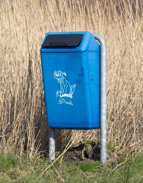 Close up of bright blue dog mess poop bin