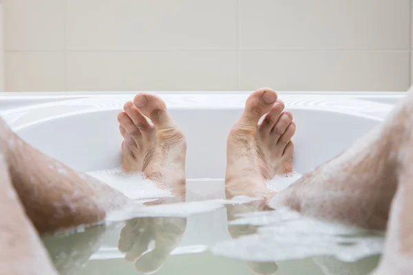 Men\'s feet in a bathtub, selective focus on toes