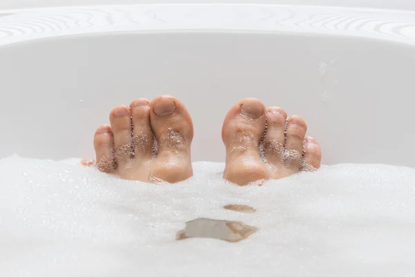 Men\'s feet in a bathtub, selective focus on toes