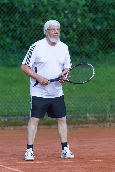 Senior man playing tennis