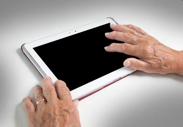 Hands of senior lady relaxing and reading the screen of her tabl