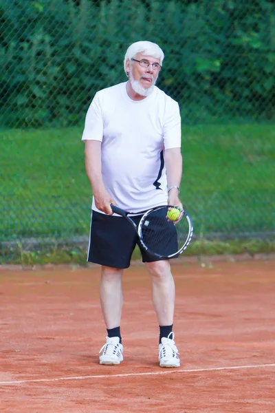 Senior man playing tennis