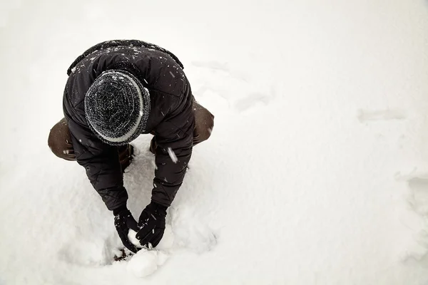 Young adult making snow ball