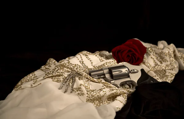Revolver laying on a Woman\'s Evening Dress