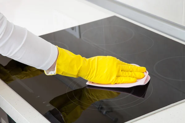 Housewife cleaning an induction plate