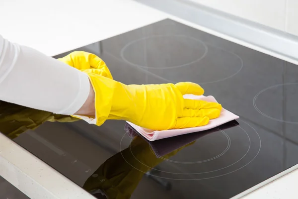 Housewife cleaning an induction plate