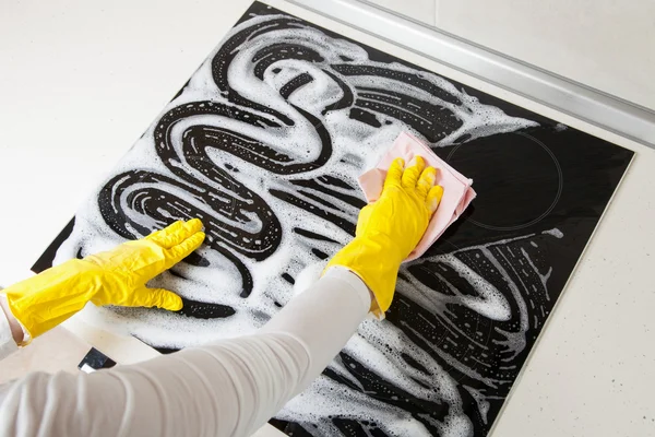 Housewife cleaning an induction plate