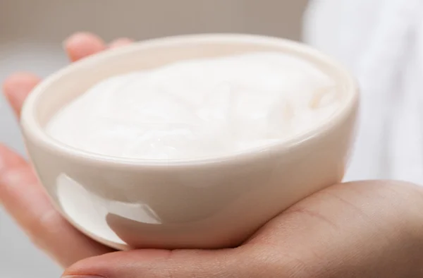 Hand holding  bowl with nourishing mask