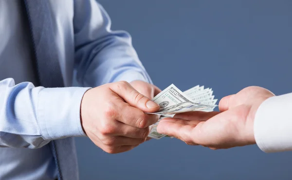 Human hands exchanging money on blue background