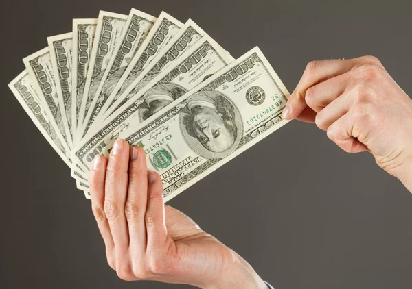 Human hands holding fan of dollars