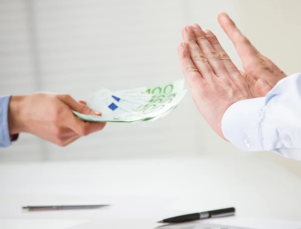 Hands rejecting an offer of money
