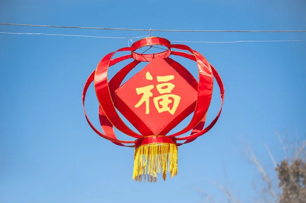 Red Chinese lantern hanging against a clear blue sky