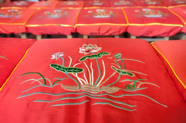 Lotus flower pattern on a red prayer cushion at a Chinese temple