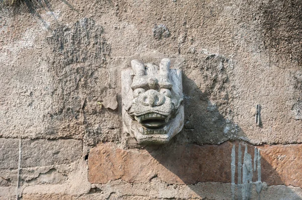 Stone dragon head water spout on a Suzhou canal, China