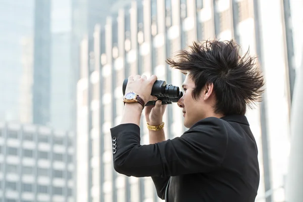 Businessman search stock through binoculars