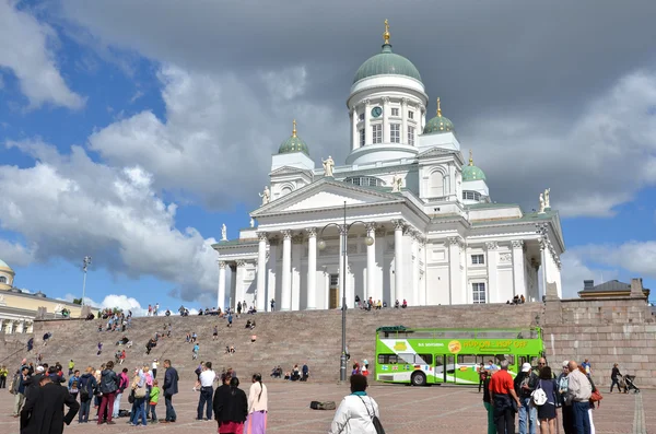 HELSINKI / FINLAND - July 20, 2013: White Helsinki Cathedral, the evangelical lutheran church. At the picture are many people and green tourist bus.