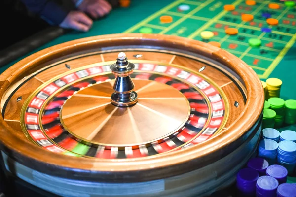 Roulette in motion. Green table with colored chips ready to play.