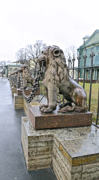 Several statues of bronze lions along the fence in St. Petersbur