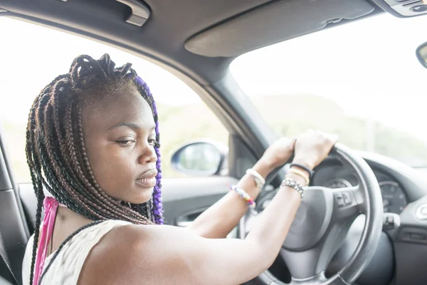 Beautiful pensive african female driver sitting in the car.