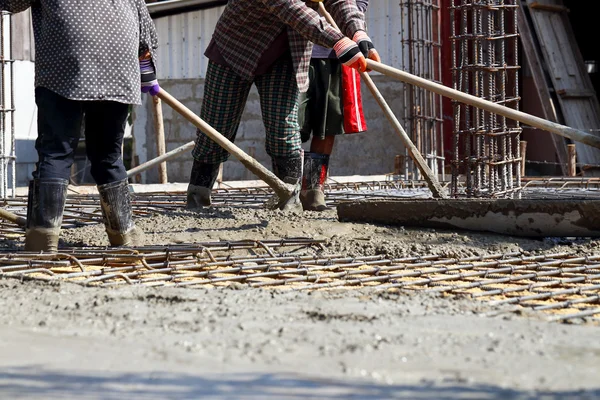 Workers pouring cement outdoor