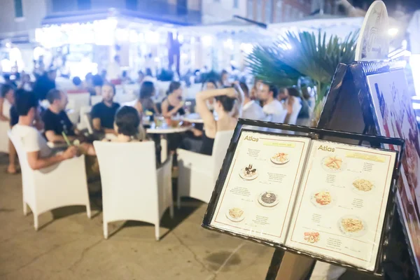Tourist menu displayed in front of restaurant on promenade