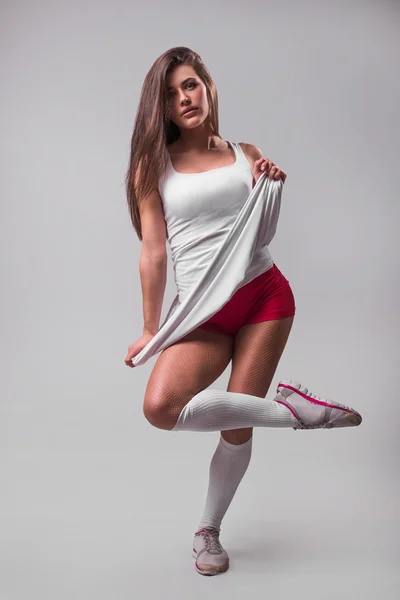 Studio portrait of a young beautiful sporty woman, wearing   sports shorts